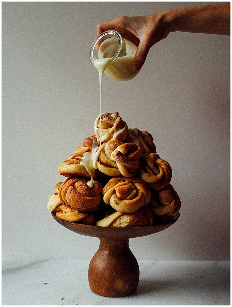 Orange Cardamom Rolls recipe by The Wood and Spoon Blog by Kate Wood. Recipe adapted from food52. Simple twists of dough filled with cardamom, orange zest, and cinnamon. These are topped with a cream cheese icing/ frosting / glaze. These can be re warmed and made ahead. These Buns are easy to twist and I'll show you how to roll them on thewoodandspoon.com . Breakfast idea, brunch idea, Christmas breakfast, holiday breakfast, cinnamon rolls buns, recipes using cardamom.