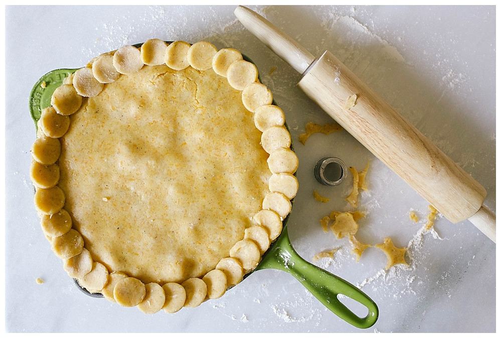 Cheddar Cornmeal Chicken Pot Pie recipe by The Wood and Spoon Blog by Kate wood. Adapted from ina garten's recipe, this pot pie is made in a skillet or dutch oven and it super simple. The pie crust has cheddar cheese and corn Meal, thyme, rosemary, and other herbs and is flaky from butter and shortening- it ends up tasting like a cheese straw! The filling has peas, pearl onions, and carrots and is thickened by a roux made of flour and butter. Find this comfort food recipe to serve for a cold weather family dinner on thewoodandspoo.com . pastry, pie.