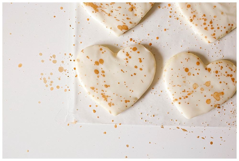 Lavender Vanilla Bean Sugar Cookies Recipe by The Wood and Spoon Blog by Kate Wood and Abby Hollar of The Hollardays Blog. This is a simple recipe for homemade cutout sugar cookies flavored with dried lavender and vanilla bean paste. The icing is simple and dries quick and doesn't require a piping bag or tip like Royal icing. The gold lustre luster dust is mixed with alcohol to create a shiny metallic paint that you can splatter on your cookies with a basting brush. Find the tutorial and how to paint cookies on thewoodandspoon.com