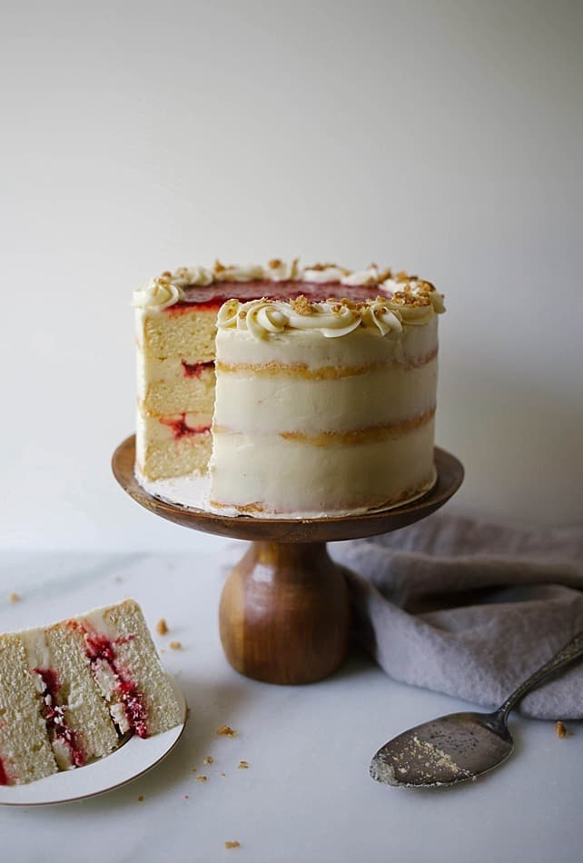 Raspberry Streusel Cake Recipe by The Wood and Spoon Blog. Three layers of brown sugar vanilla cake filled with a quick and simple raspberry compote and sprinkles of cinnamon sugar streusel crumble. The naked cake is coated in a tangy cream cheese frosting. This layer cake can be prepared in parts days in advance and stays moist over time. Find this party cake recipe (perfect for holidays and Mother's Day !) on www.thewoodandspoon.com / woodandspoon.com