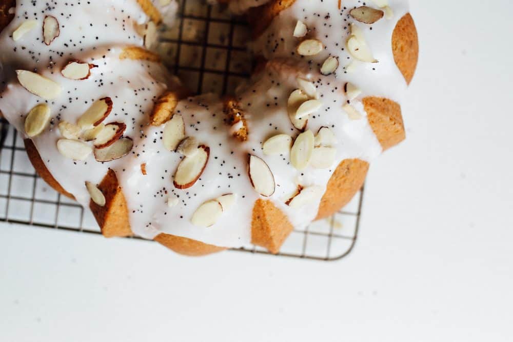 Lemon Almond Poppyseed Bundt Cake Recipe Recipe by the wood and spoon blog by kate wood. This is a simple, fluffy, golden and white almond cake speckled with poppyseed and lemon zest and juice. The cake is spongy and perfect for breakfast or dessert. The whole thing is topped with a simple sugar glaze icing and slivered almonds. Find this springtime bundt cake recipe on thewoodandspoon.com.