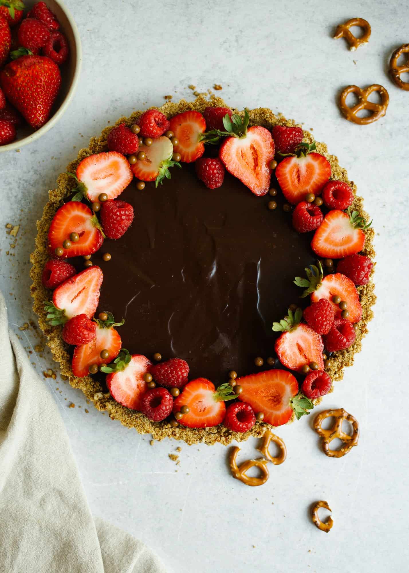 Double Chocolate Ganache Tart by Wood and Spoon. This is a pretzel and brown sugar crust filled with two types of ganache. First, a white chocolate ganache and then a rich dark chocolate ganache. Learn how to make easy ganache for this beautiful make ahead fruit and chocolate tart in a sweet and salty press in pie crust. Find the recipe on thewoodandspoon.com