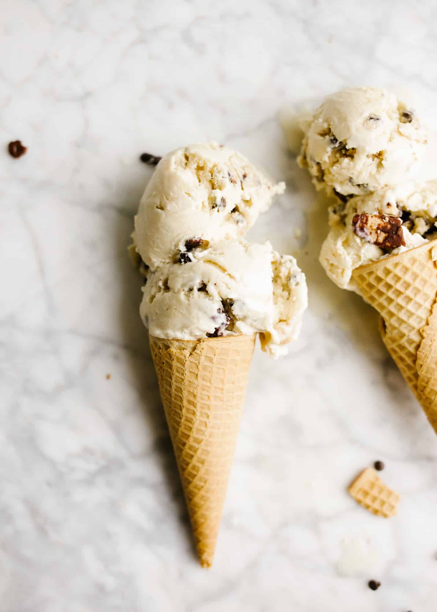 Brown Sugar Cookie Dough and Cone Ice Cream by Wood and Spoon blog. This is a brown sugar ice cream base loaded with chunks of eggless cookie dough and chocolate coated waffle cone pieces. The end product is like a cookies and ice cream dessert with tons of texture, chocolate, and flavor! Learn how simple it is to make this ice cream machine ice cream from thewoodandspoon.com