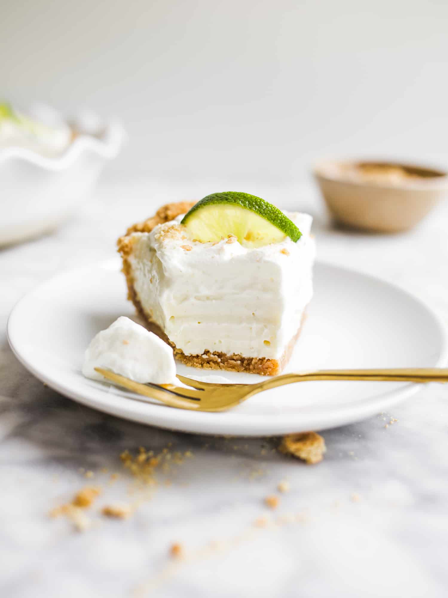 Creamy Key Lime Pie by Wood and spoon blog. This is a simple key lime pie that doesn't require the stovetop. Cream cheese, condensed milk, and key lime juice make this simple pie with a sweet and salty graham cracker crust. This is a great make ahead dessert that can be prepped in less than 30 minutes. Find this summery recipe on thewoodandspoon.com