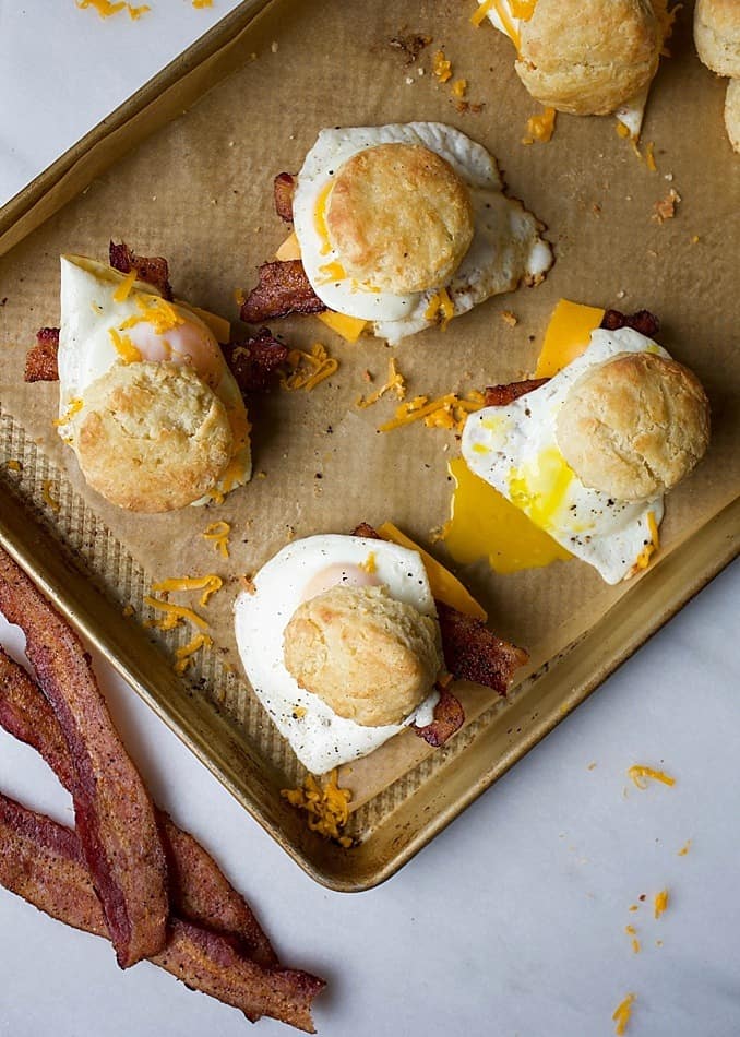 Buttermilk Biscuits and Pepper Bacon Egg and Cheese Biscuit Sandwiches. Flaky, all butter, Southern style biscuits with tons of layers topped with peppery bacon, cheddar cheese and a fried or scrambled egg. These breakfast sandwiches are perfect for the morning or brunch hour and makes a simple breakfast for the man / men in your life this Father's Day. Take these sandwiches on the go! Recipe by thewoodandspoon.com