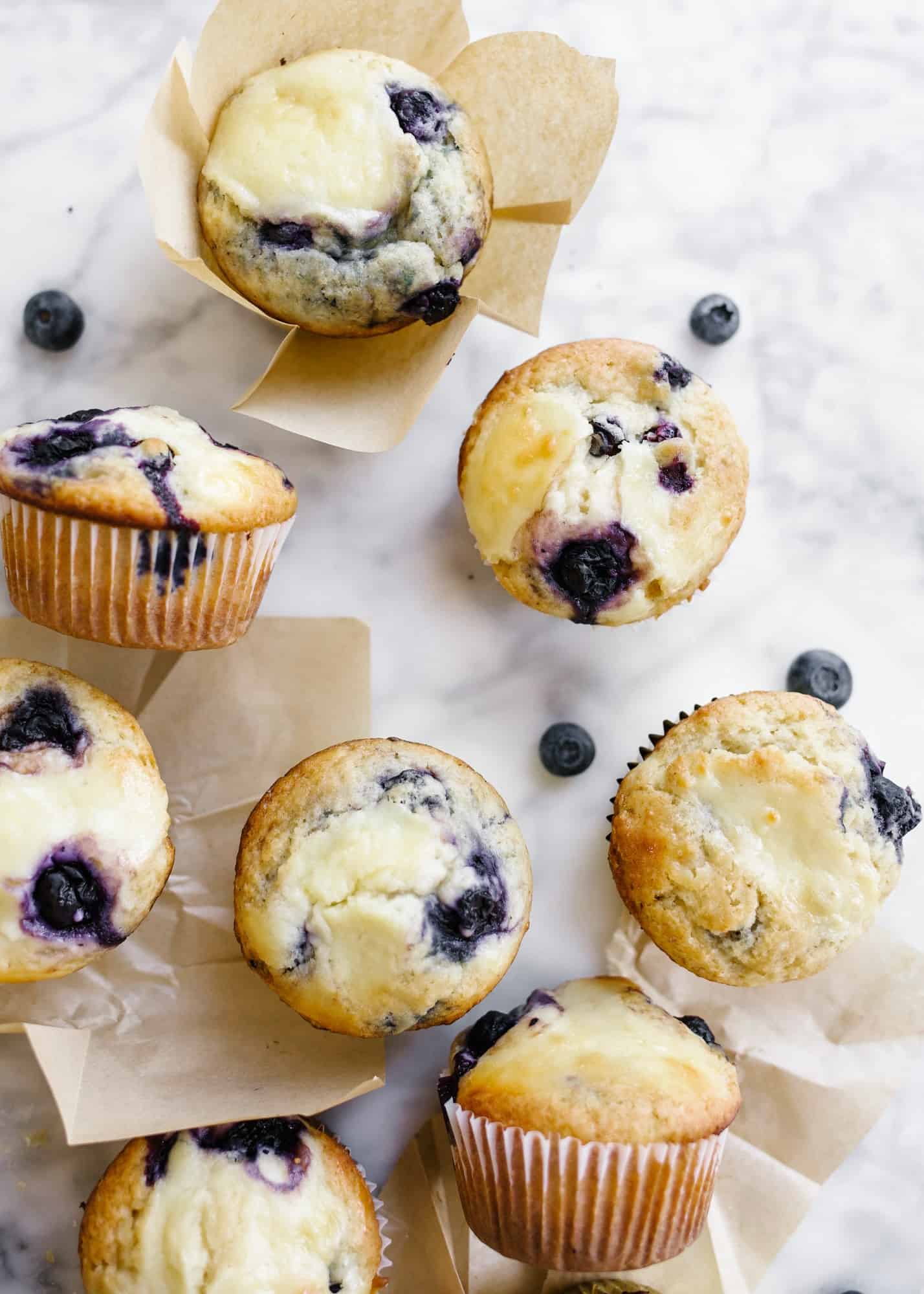 Blueberry Cream Cheese Muffins by Wood and Spoon blog. These are soft and fluffy blueberry muffins swirled with a tangy cream cheese filling. These breakfast pastries make for an interesting spin on the normal morning muffin and taste delicious served warm! Learn how simple it is to make these butter muffins on thewoodandspoon.com