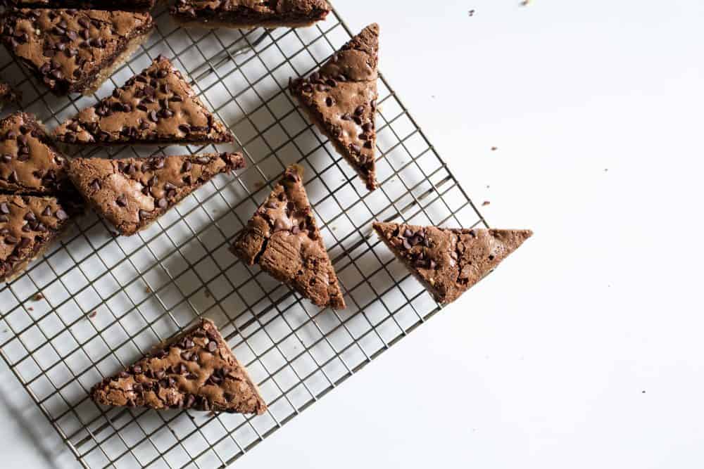 Pretzel Shortbread Peanut Butter Brownies Recipe by The Wood and Spoon Blog by Kate Wood. This is a layered dessert made in a sheet pan. A salty pretzel shortbread crust with butter and brown sugar. There is a soft and creamy peanut butter cup filling. The whole thing is topped with a chocolate chip brownie made from melted chocolate bars and chips. Adapted from ina garten's brownie recipe. This serves a crowd and is great for a party barbecue or gathering. Recipe at thewoodandspoon.com