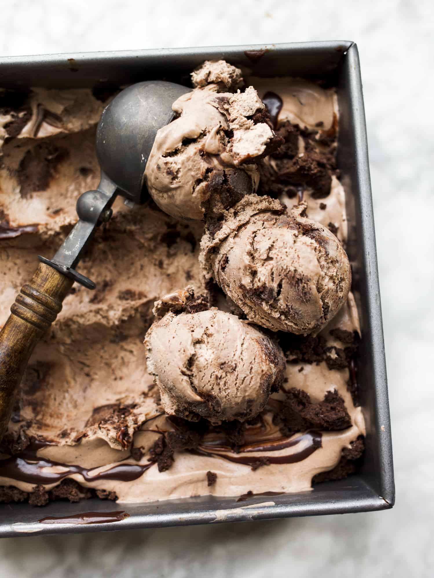 no-churn mocha brownie fudge ice cream recipe by the wood and spoon blog by kate wood. This is a simple ice cream that requires no maker or machine. It's whipped cream and sweetened condensed milk, flavored with brownie mix and filled with dark hot fudge sauce and bits of brownie pieces. Find the recipe for this creamy summertime favorite, best no churn ice cream on thewoodandspoon.com