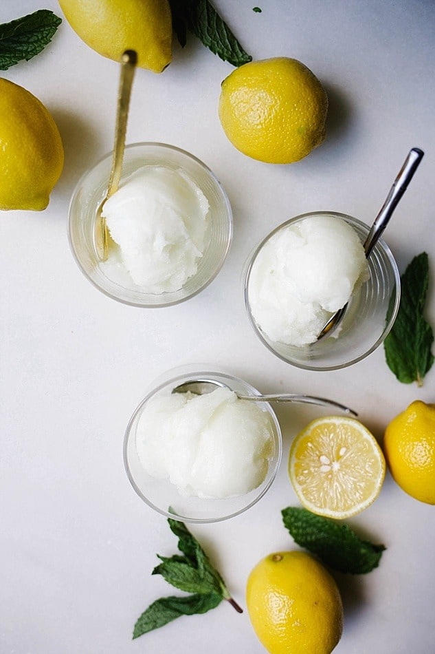 Lemon Mint Sorbet Recipe by The Wood and Spoon Blog by Kate Wood. This is a refreshing, frozen, lemon and mint sorbet made with freshly squeezed lemon juice, mint, and simple syrup. This ice cream is made in a ice cream maker and requires very little active prep time. Similar to a granita or frozen Italian ice, this treat is the perfect dessert to serve on a hot day! Find the recipe on thewoodandspoon.com