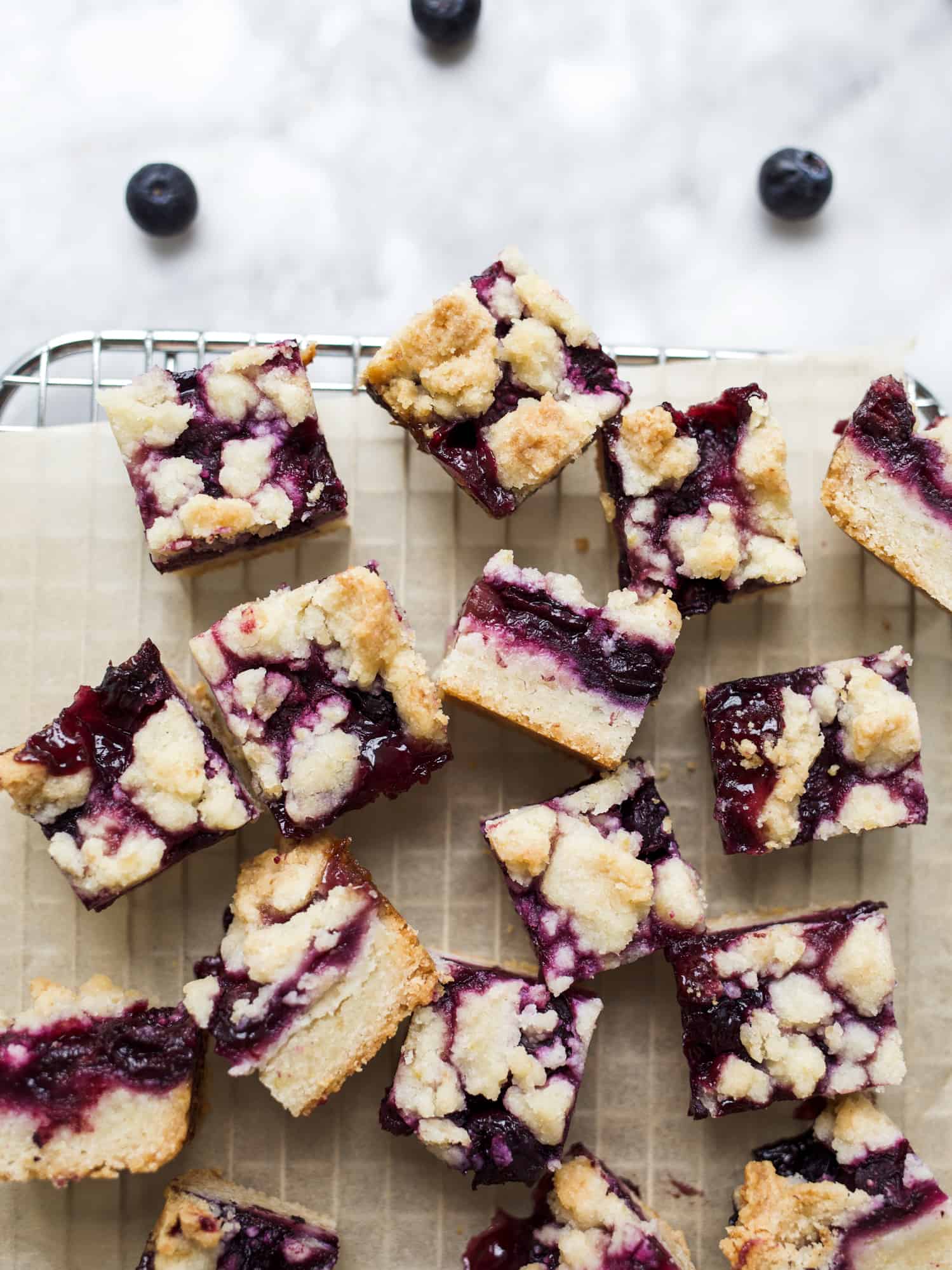 Blueberry Lemon Bars Recipe by the Wood and Spoon Blog by Kate Wood. This is a simple shortbread crust summer berry fruit bar. The shortbread is lemon zest scented and the blueberry filling is full of more zest and lemon juice. The crumbles on top of buttery and add a crunch to this juicy fruit bar. Make a small or large batch for a crowd. thewoodandspoon.com