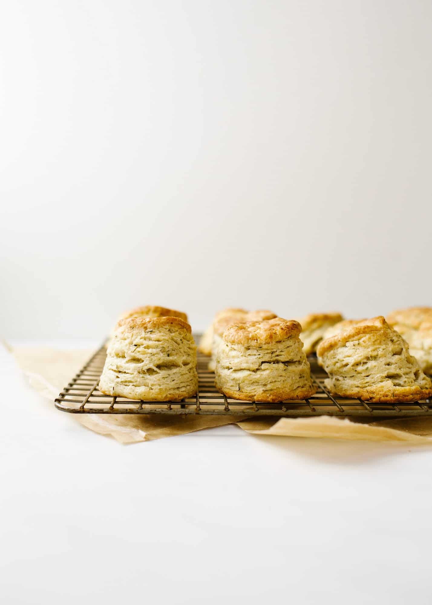 Mini Garlic Herb Biscuits by Wood and Spoon blog. These are bite-sized southern style biscuits layered with garlic, herbs, and loads of butter. These breakfast breads make a great side option for suppers but can also be used as a base for breakfast sandwiches and more! Learn how simple it is to make them on thewoodandspoon.com