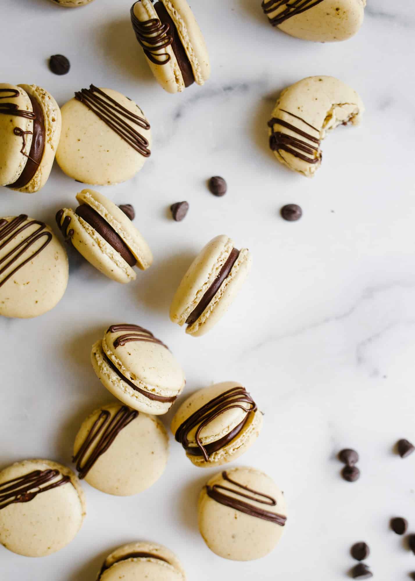 Mocha Macarons by Wood and spoon. Theres are coffee espresso flavored French macaron shells filled with a rich semisweet chocolate ganache scented with coffee! Learn how to make these elegant delicate fancy cookies on thewoodandspoon.com by Kate Wood