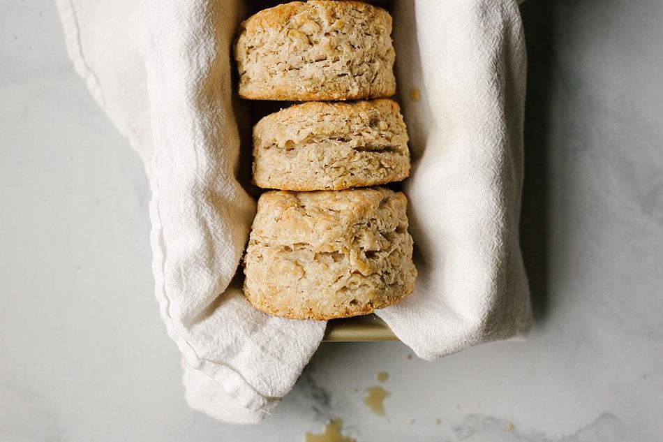 Maple Oatmeal Biscuits Recipe by The Wood and Spoon blog by Kate Wood. This is a simple, one bowl recipe for southern style fluffy layered biscuits filled with rolled oats and pure maple syrup. The biscuits are tall and thick, soft from the addition of buttermilk. Naturally sweet with maple syrup, these are best served for breakfast or as an easy addition to brunch. Find the recipe and the how to on thewoodandspoon.com