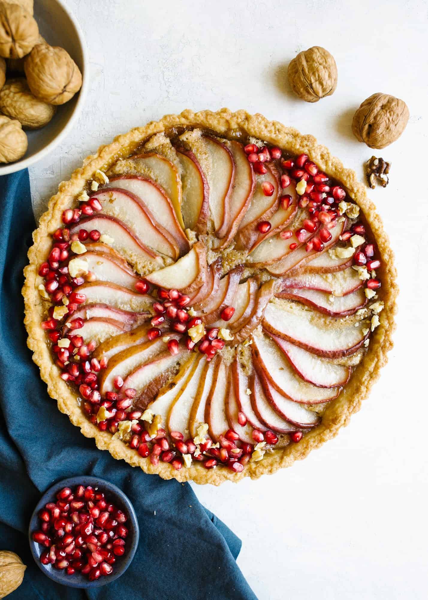 Brown Butter Pear Tart and our time in Boston and Martha's Vineyard. This is the recipe for a sweet pastry crust tart filled with brown butter custard and layered red pears. Fresh pomegranate top the pretty holiday dessert for a crowd. Can be served at room temperature and made ahead. Read more about our trip to new England coast to Martha's Vineyard and historical Boston with this foodie guide of what to eat and see and do and where to stay. by wood and spoon blog by Kate Wood