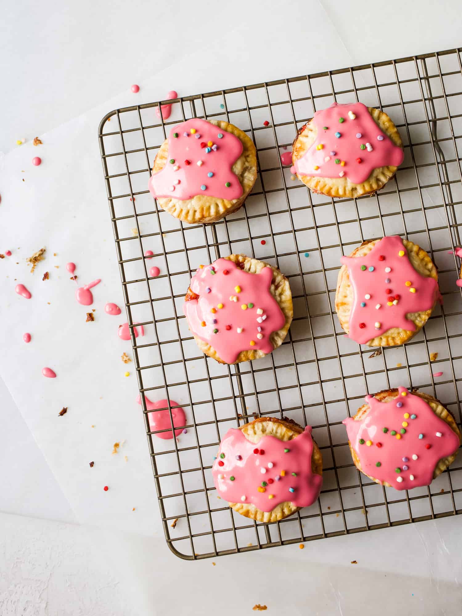 Strawberry Fig Pop-Tarts Recipe by The Wood and Spoon Blog by Kate Wood. This recipe is for mini round pop tarts make of butter pie crust pasty and simple homemade strawberry fig preserves. Top with an easy confectioner's sugar icing glaze and sprinkles for a fun breakfast or dessert. Find the recipe for the jam and these simple mini hand pie pastries on thewoodandspoon.com