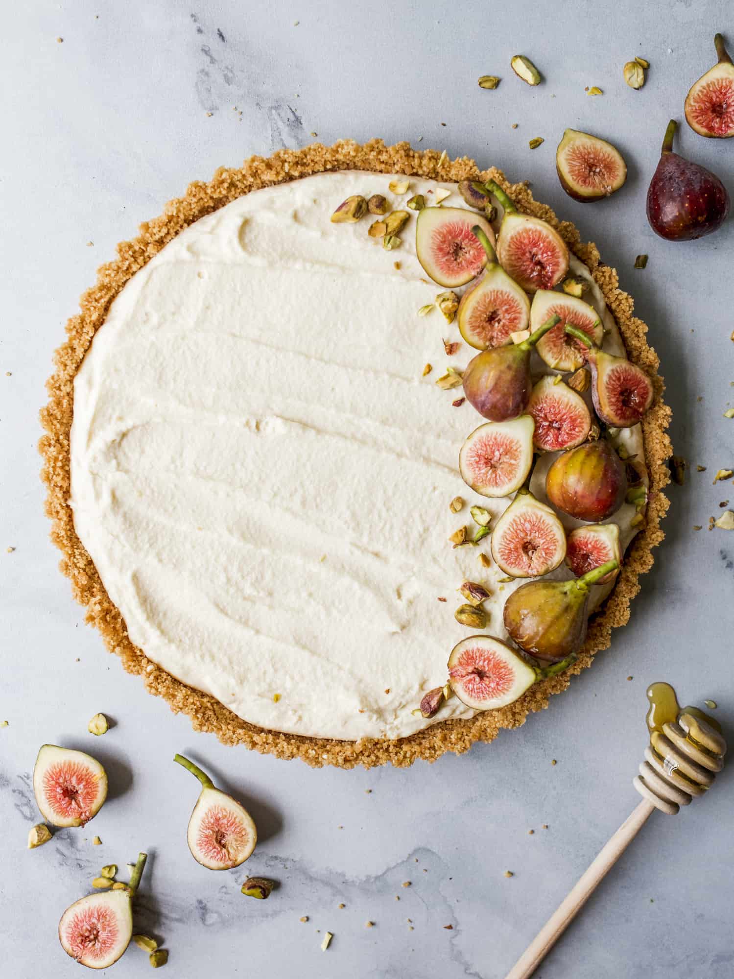 Honey Mascarpone Tart By The Wood and Spoon Blog by Kate Wood. This is a simple, summer dessert. A no-bake cheesecake tart of sorts with a salty press in graham cracker and a creamy cheese filling. The tart is naturally sweetened with honey and is topped with toasted pistachios and fresh figs. This dessert can be made ahead and is quick- it takes less than 30 minutes of prep time. Make this little tartlet in place of summer pies. Find the whole recipe and photos on thewoodandspoon.com