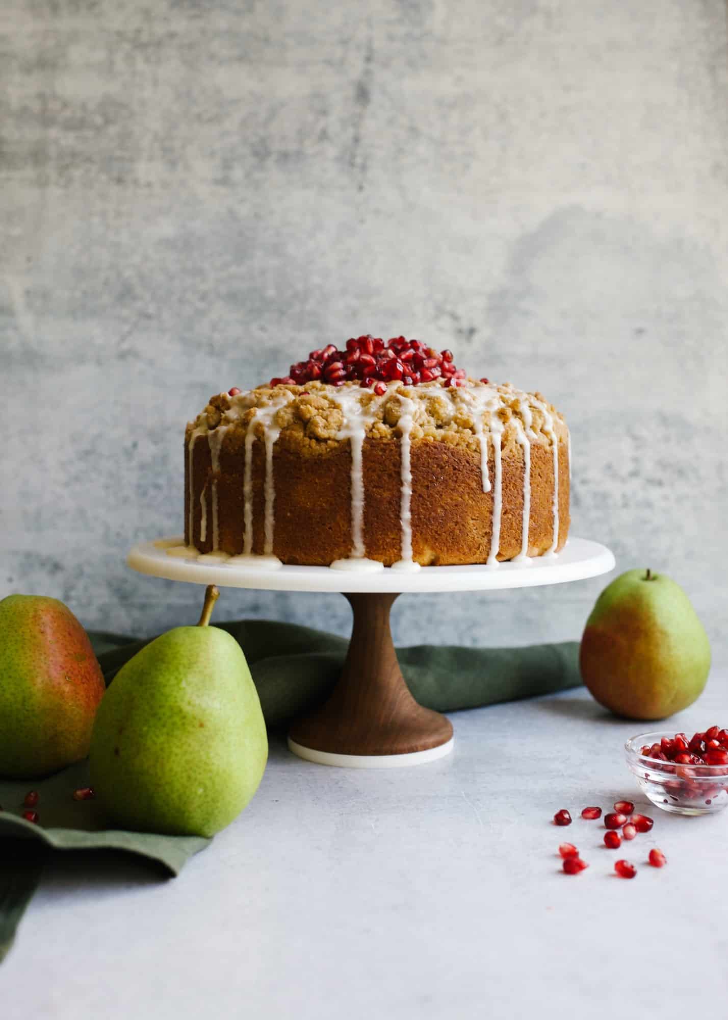 Pear Almond Cake by Wood and Spoon blog by Kate Wood. This is a simple pound cake bundt cake with a streusel crumb topping that is loaded with fresh sweetened pear fruit and almond flavor. The coffee cake makes a great breakfast or dessert treat or snack for your holiday winter tables. Learn more about the recipe and how to prep this simple cake that can be garnished with pomegranate seeds on thewoodandspoon.com