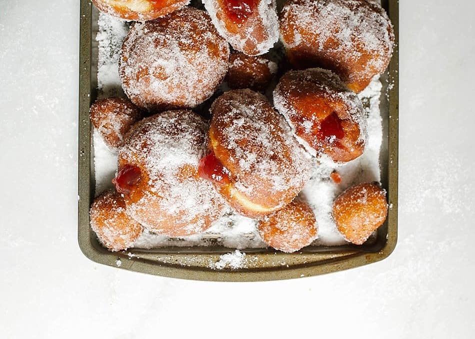 Jelly Donuts and a Saveur Blog Awards Nomination Recipe by The Wood and Spoon Blog by Kate Wood. Find the recipe for these fluffy yeast doughnuts filled with fruity jam and covered with sugar. These are fried donuts that are tossed in cinnamon sugar, powdered sugar, or granulated sugar. Find the recipe and the how to for these stuffed pastries (also known as Berliners) on thewoodandspoon.com