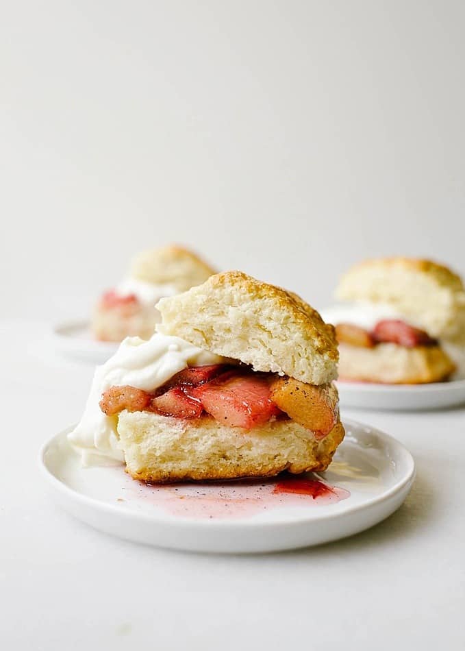 Rhubarb Shortcakes by The Wood and Spoon blog. These are scone like biscuits topped with a roasted rhubarb and vanilla bean and whipped mascarpone cream. The cakes are tender and layered and flaky, while the fruit is sweet and tangy. This is a great way to use up rhubarb and is a great summer dessert for a party. Read more about the recipe and how to on thewoodandspoon.com