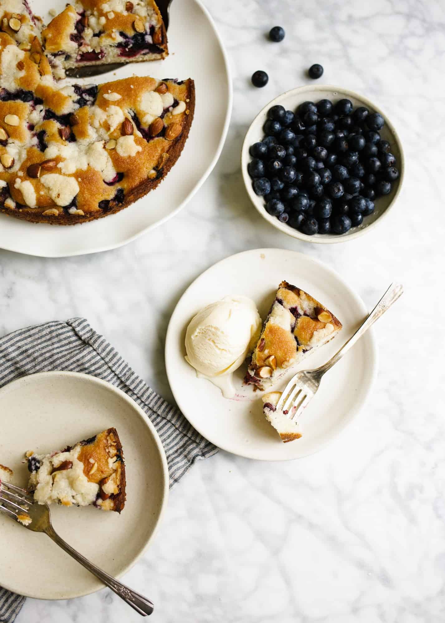 Berry Buckle by Wood and Spoon blog. This is a simple breakfast cake / dessert dotted with summer blackberries and blueberries and topped with an almond streusel. The cake bakes up well and is delicious served with whipped cream and ice cream. Learn how simple the recipe is at woodandspoon.com