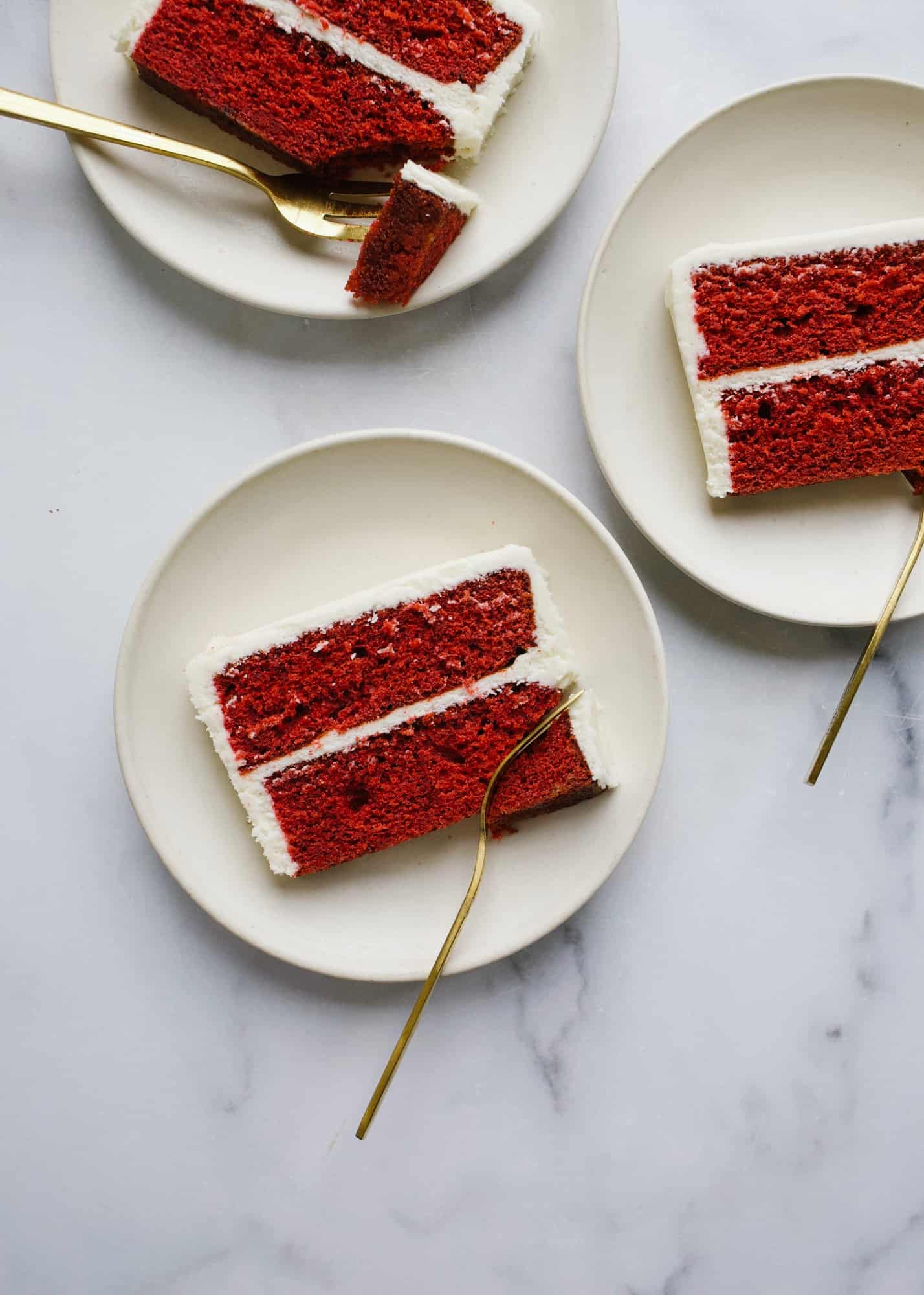 Red Velvet Cake by Wood and Spoon blog. This is a cocoa flavored layer cake with a tangy cream cheese frosting. This recipe is fluffy and festive with bright red layers and is perfect for holiday baking or birthday celebrations. Learn more about how to make this dessert on thewoodandspoon.com by Kate Wood