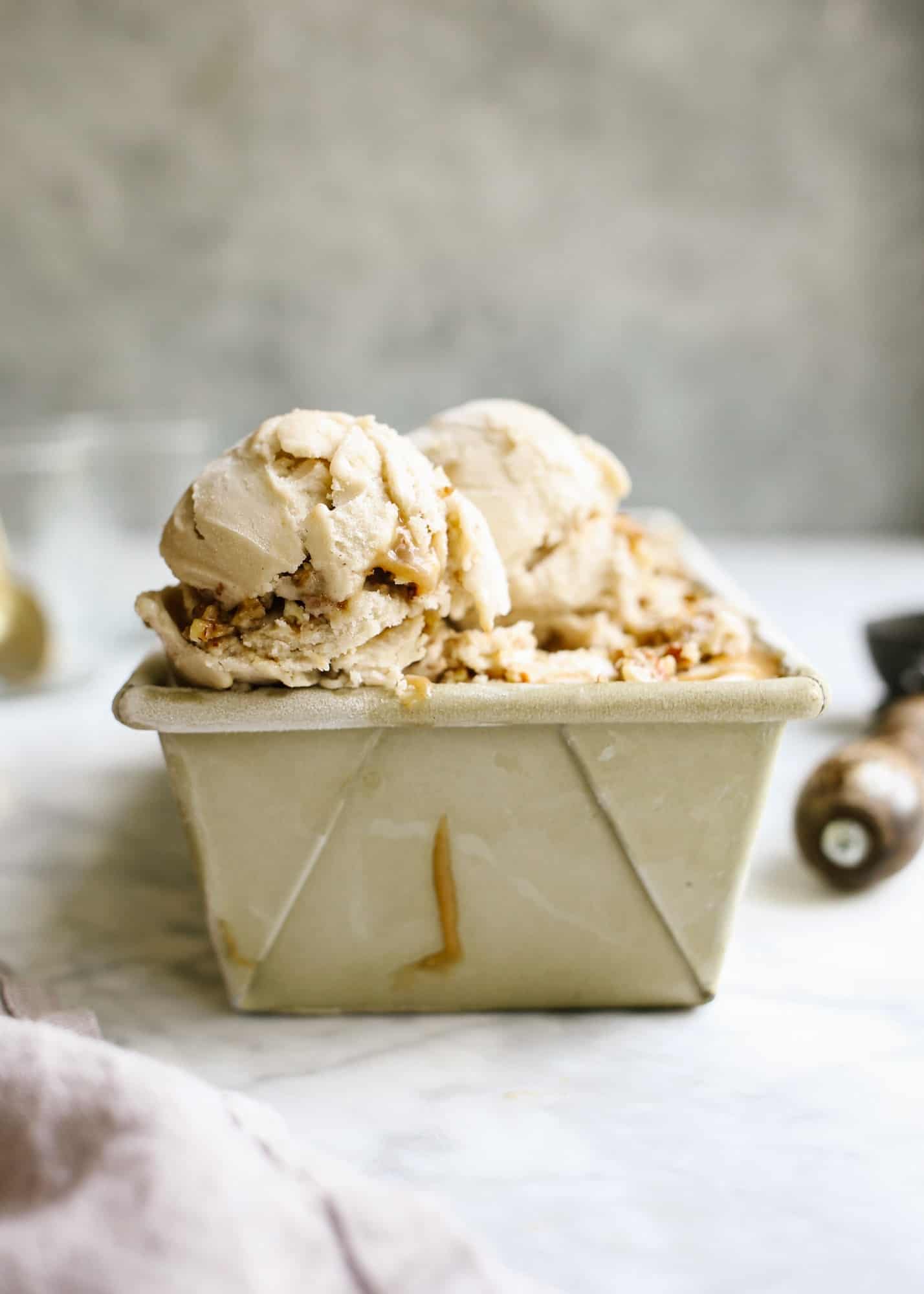 No-Churn Bananas Foster Ice Cream by Wood and Spoon blog. This is a one ingredient ice cream made with frozen bananas, all gussied up with the addition of a rum foster sauce and praline pecans. The ice cream comes together in a blender and is swirled with the stovetop bananas foster sauce and candied nuts. Learn how simple this nice cream is (with options for dairy free ice cream!) on thewoodandspoon.com.