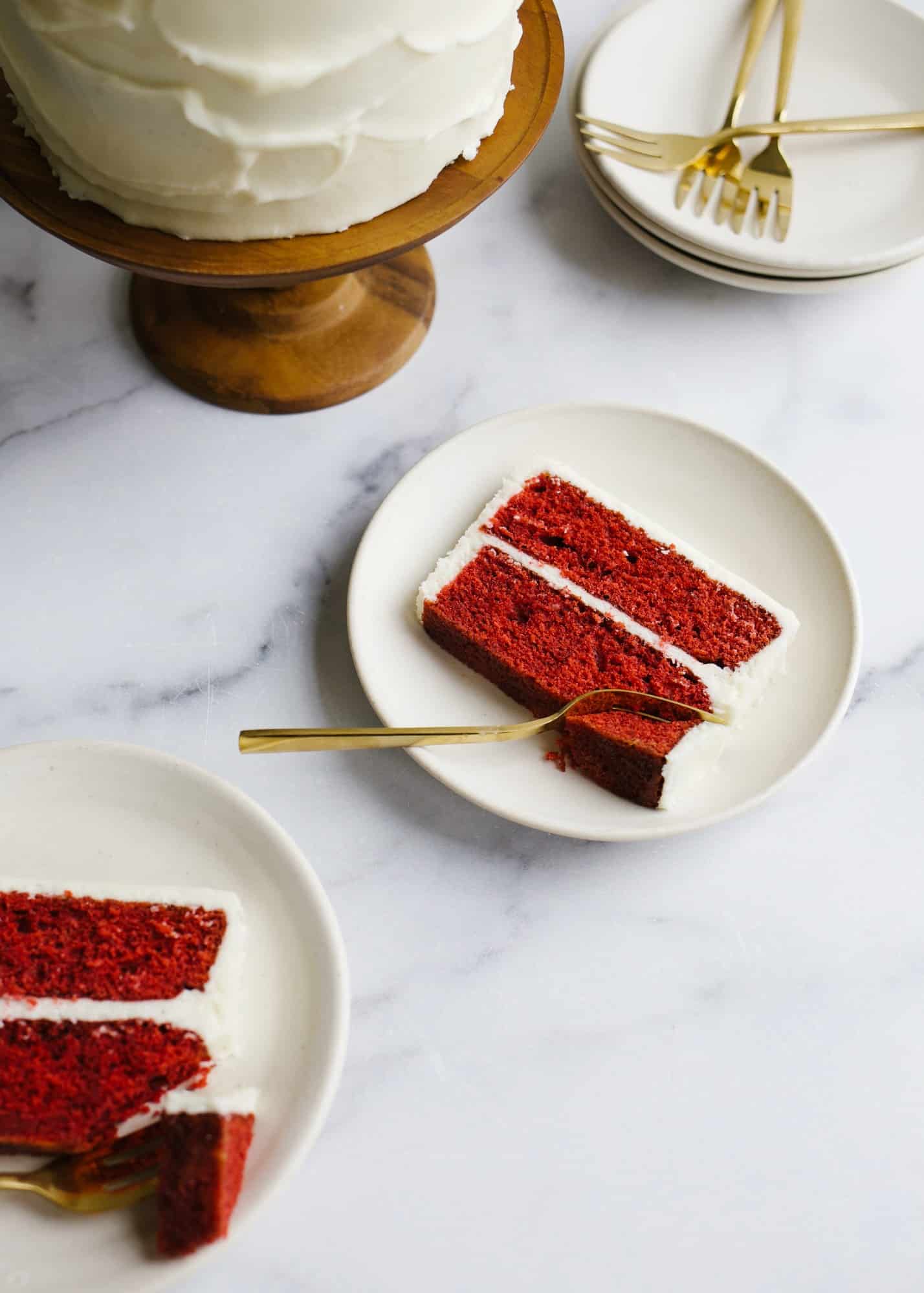 Red Velvet Cake by Wood and Spoon blog. This is a cocoa flavored layer cake with a tangy cream cheese frosting. This recipe is fluffy and festive with bright red layers and is perfect for holiday baking or birthday celebrations. Learn more about how to make this dessert on thewoodandspoon.com by Kate Wood