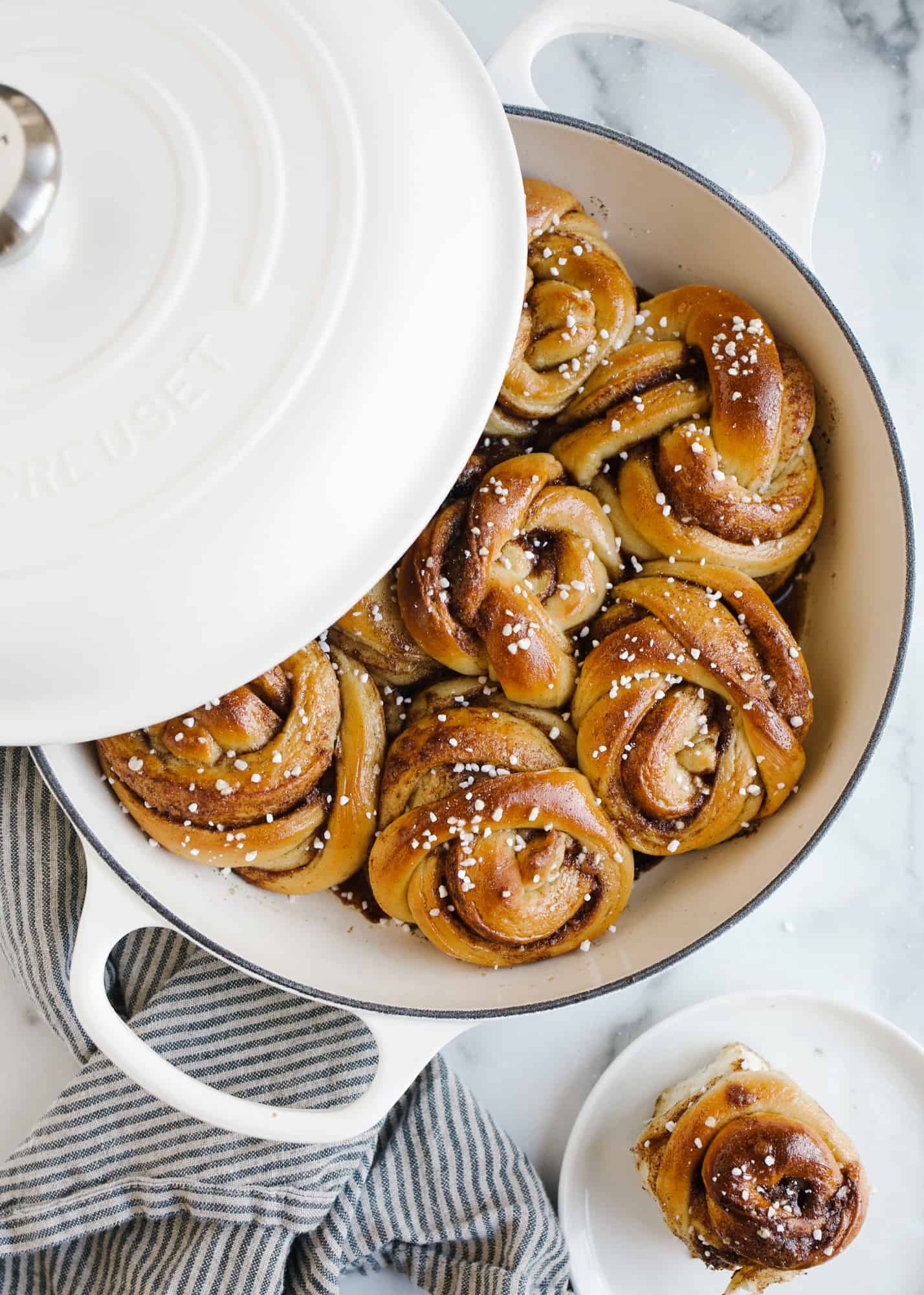 Swedish Cinnamon Rolls by Wood and Spoon blog. These are twisted and knotted cinnamon rolls filled with a sugar spiral filling and dotted with Swedish pearl sugar. Cardamom and spices flavor the dough and filling. These make delicious breakfast brunch or dessert pastries and can be topped with a glaze if desired. Read more on the recipe on thewoodandspoon.com