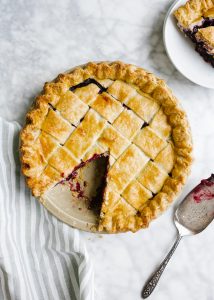 Blueberry Maple Pie by Wood and Spoon blog. This is a flaky crusted summer fruit blueberry pie naturally sweetened with maple syrup and barely spiced with a hint of cinnamon. This summer dessert transition into a fall treat seamlessly with ripe produce and warm flavors. Learn how simple it is to make an old fashioned southern lattice pie on thewoodandspoon.com by Kate Wood