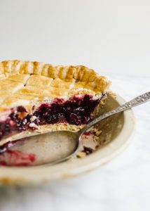 Blueberry Maple Pie by Wood and Spoon blog. This is a flaky crusted summer fruit blueberry pie naturally sweetened with maple syrup and barely spiced with a hint of cinnamon. This summer dessert transition into a fall treat seamlessly with ripe produce and warm flavors. Learn how simple it is to make an old fashioned southern lattice pie on thewoodandspoon.com by Kate Wood