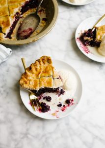 Blueberry Maple Pie by Wood and Spoon blog. This is a flaky crusted summer fruit blueberry pie naturally sweetened with maple syrup and barely spiced with a hint of cinnamon. This summer dessert transition into a fall treat seamlessly with ripe produce and warm flavors. Learn how simple it is to make an old fashioned southern lattice pie on thewoodandspoon.com by Kate Wood