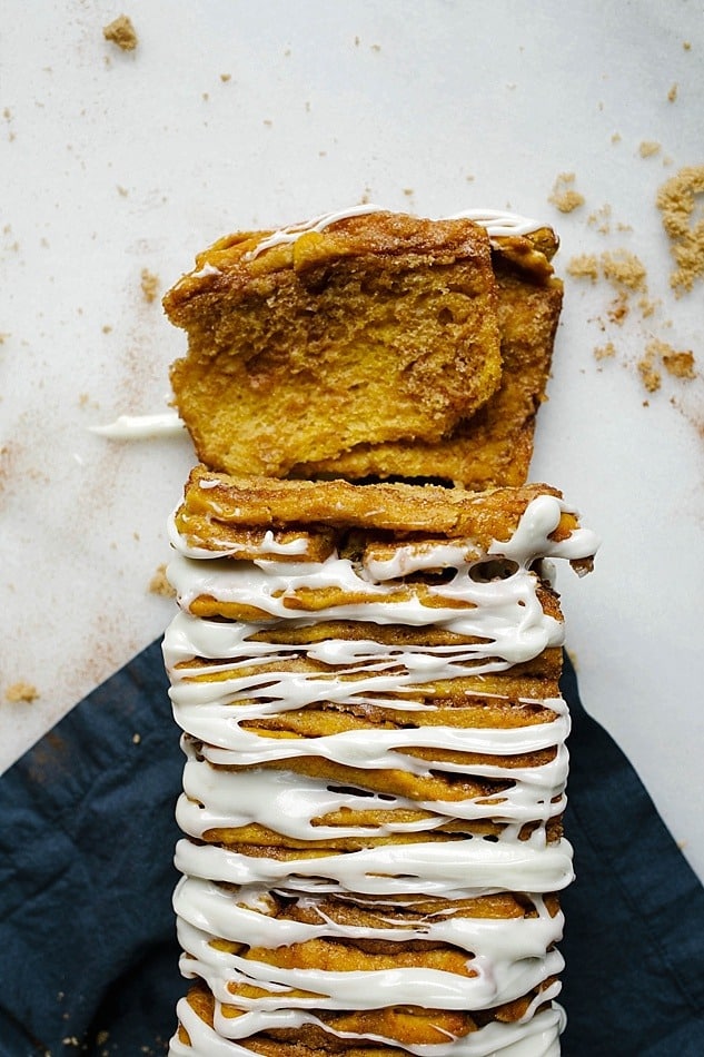 Pumpkin Pull-Apart Bread Recipe by The Wood and Spoon Blog by Kate Wood. This is a simple pull-apart bread adapted from Pioneer Woman cinnamon rolls. A kneaded dough seasoned with fall spices and filled with a gooey cinnamon sugar filling, this pumpkin pull apart bread is a treat for fall breakfasts and brunch. This is a great Thanksgiving dessert as well. The yeast bread is baked and glazed with a tangy cream cheese glaze / frosting. Find the recipe and how to on thewoodandspoon.com for this virtual pumpkin party.