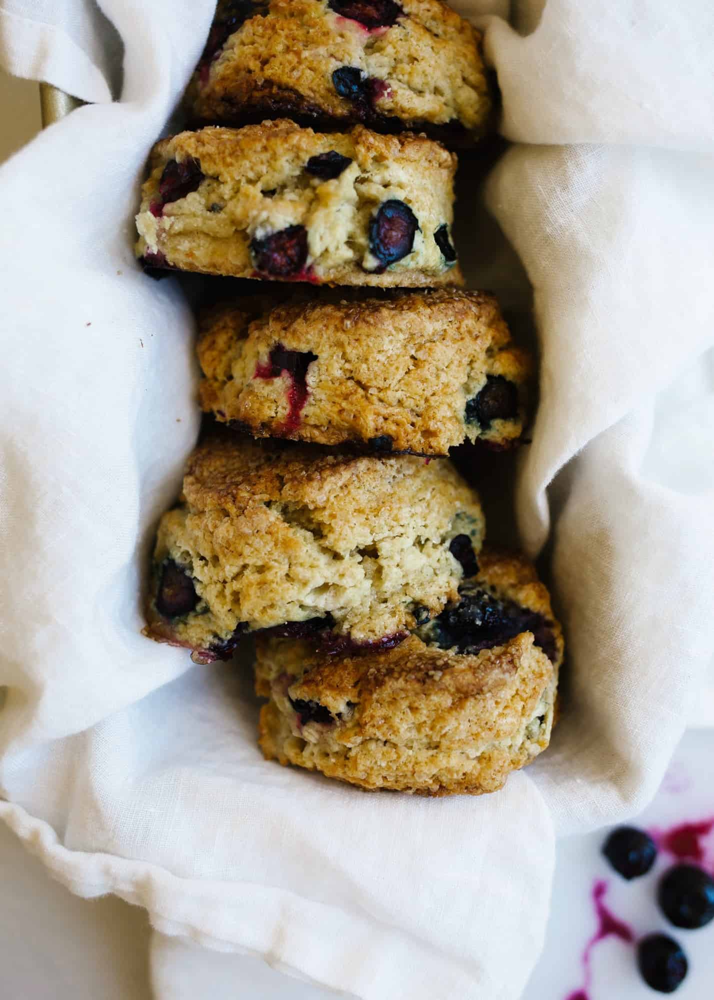 Chamomile Blueberry Scones by Wood and Spoon. These are fluffy cream and butter scones with sugared tops and an infusion of tea flavor. Blueberries are juicy throughout and flavor this richly scented breakfast treat. Perfect to share with coffee or tea. Find more about this recipe from Modest Marce on thewoodandspoon.com