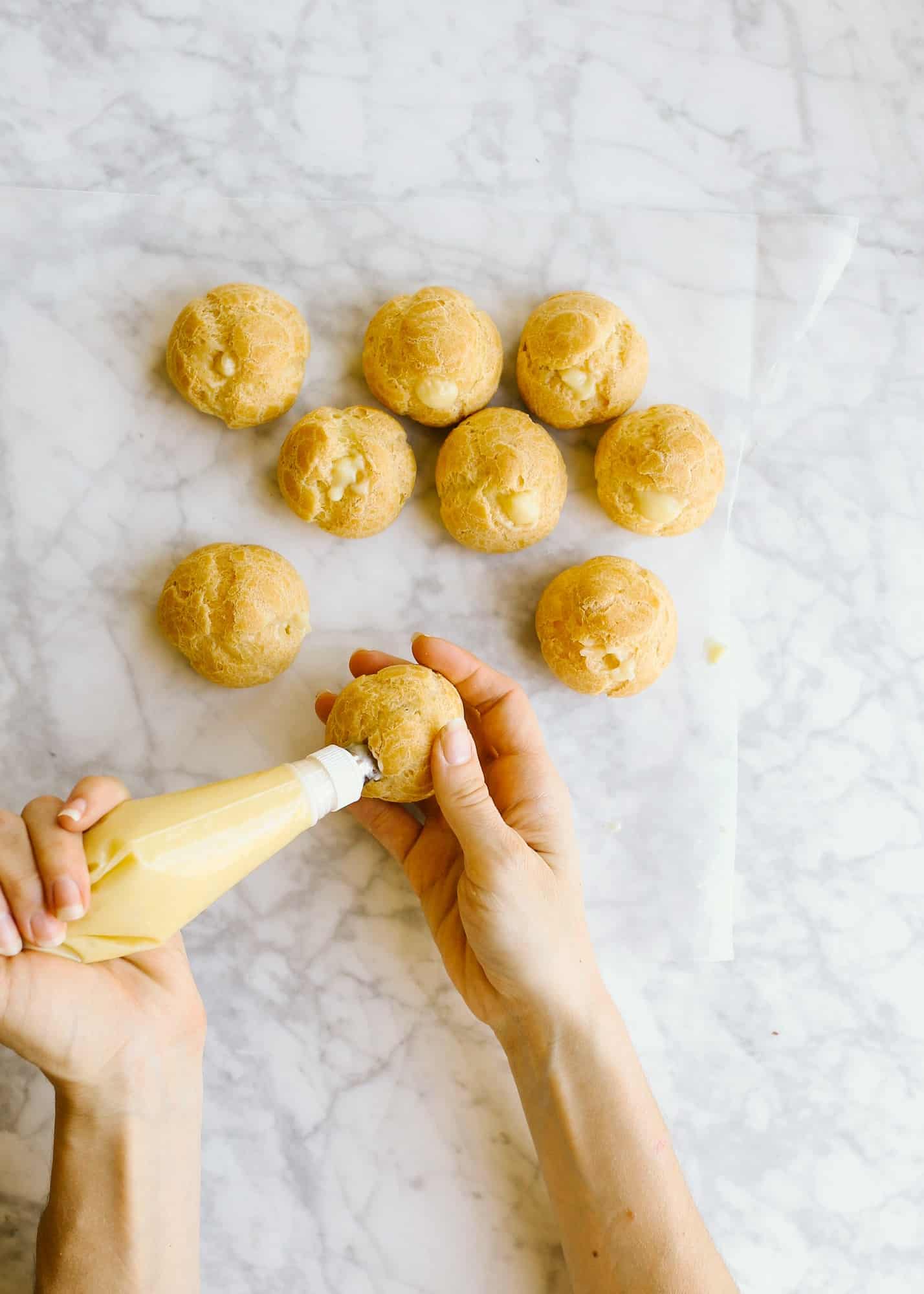 How to Make Pate a Choux and Coconut Cream Pie Puffs by Wood and Spoon. This is a step by step photographic tutorial on how to prepare French puff pastry with eggs and flour to make cream puffs profiteroles eclairs etc. Coconut cream pie custard filling is stuffed in the bites and topped with white chocolate and toasted coconut. For more on how to make this bite sized delicate fancy dessert read the recipe on thewoodandspoon.com