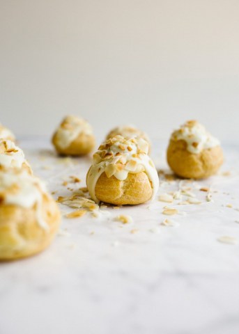 How to Make Pate a Choux and Coconut Cream Pie Puffs by Wood and Spoon. This is a step by step photographic tutorial on how to prepare French puff pastry with eggs and flour to make cream puffs profiteroles eclairs etc. Coconut cream pie custard filling is stuffed in the bites and topped with white chocolate and toasted coconut. For more on how to make this bite sized delicate fancy dessert read the recipe on thewoodandspoon.com