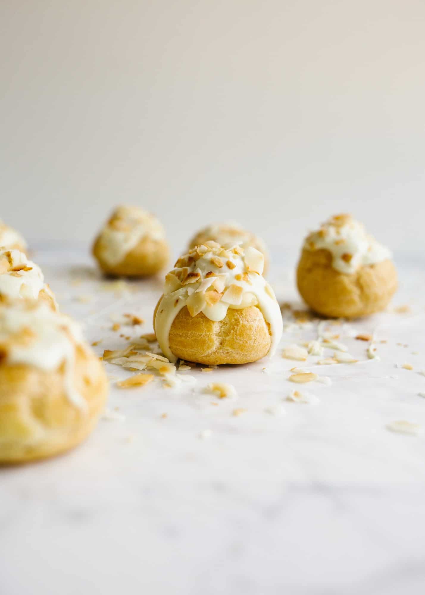 How to Make Pate a Choux and Coconut Cream Pie Puffs by Wood and Spoon. This is a step by step photographic tutorial on how to prepare French puff pastry with eggs and flour to make cream puffs profiteroles eclairs etc. Coconut cream pie custard filling is stuffed in the bites and topped with white chocolate and toasted coconut. For more on how to make this bite sized delicate fancy dessert read the recipe on thewoodandspoon.com