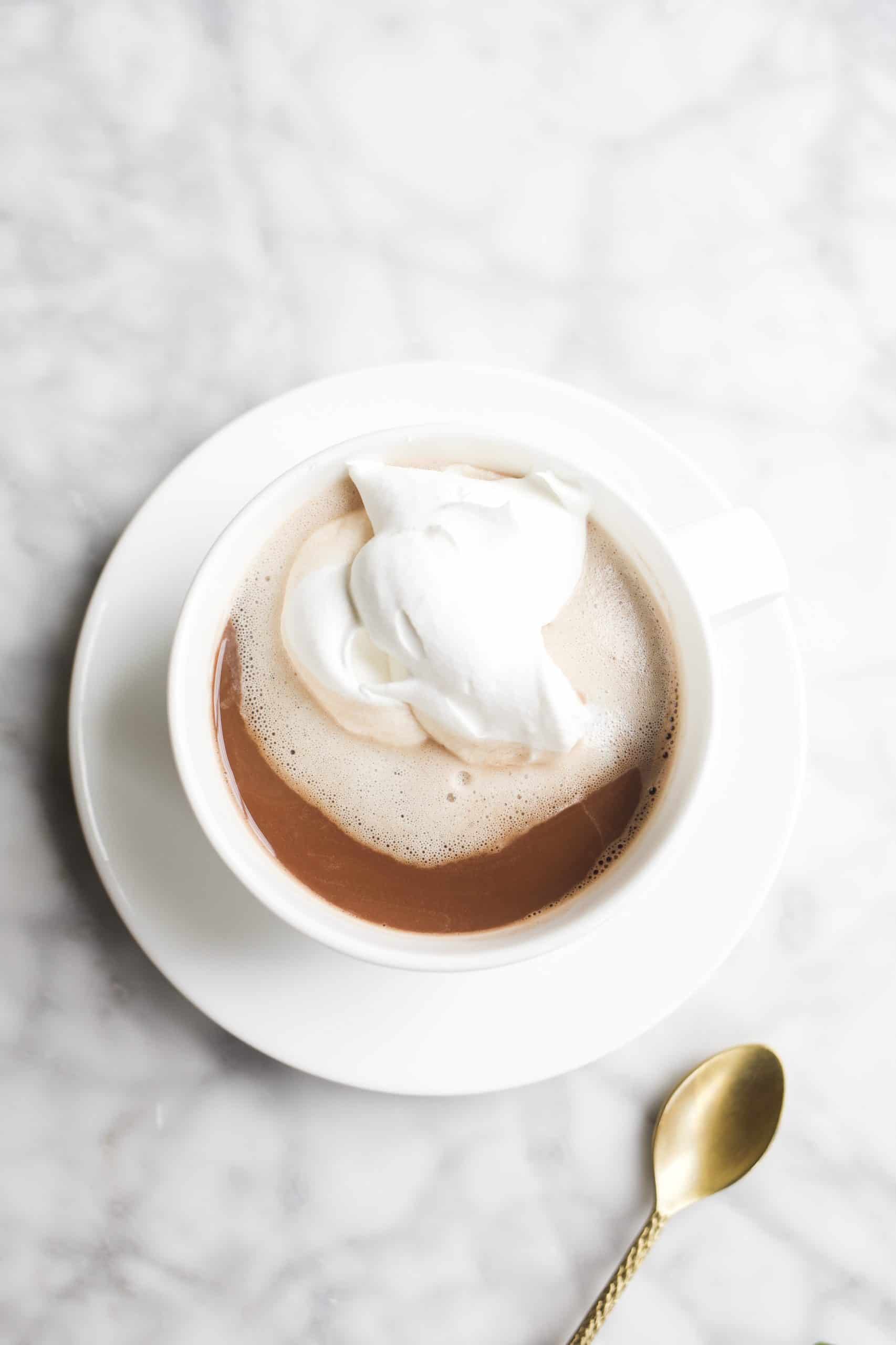 Nutella Coffee by Wood and Spoon blog. This is a recipe from Her Daily Bread book. A rich, whipped cream topped coffee sweetened with rich dollops of chocolate hazelnut spread. To learn how to make this simple beverage, find the recipe on thewoodandspoon.com