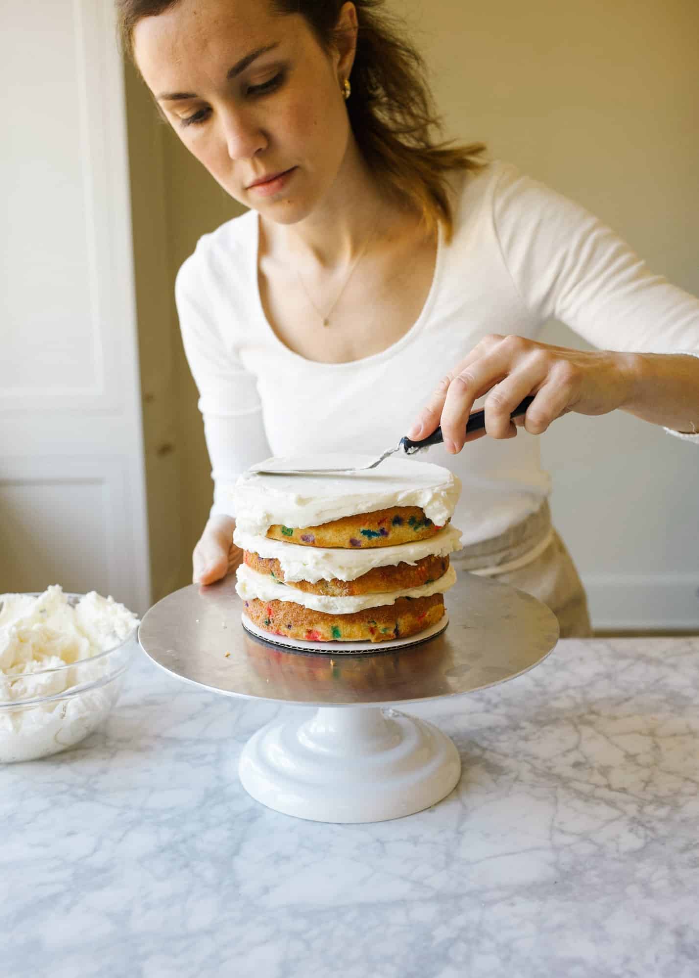 How to Stack a Layer Cake by Wood and Spoon blog. Learn the tips and how to for stacking pretty naked cakes and layer cakes from scratch homemade! Step by step tutorial with photos for learning can decorating for beginners. Learn about leveling cakes, crumb coats, filling a cake, piping borders, and more. On thewoodandspoon.com