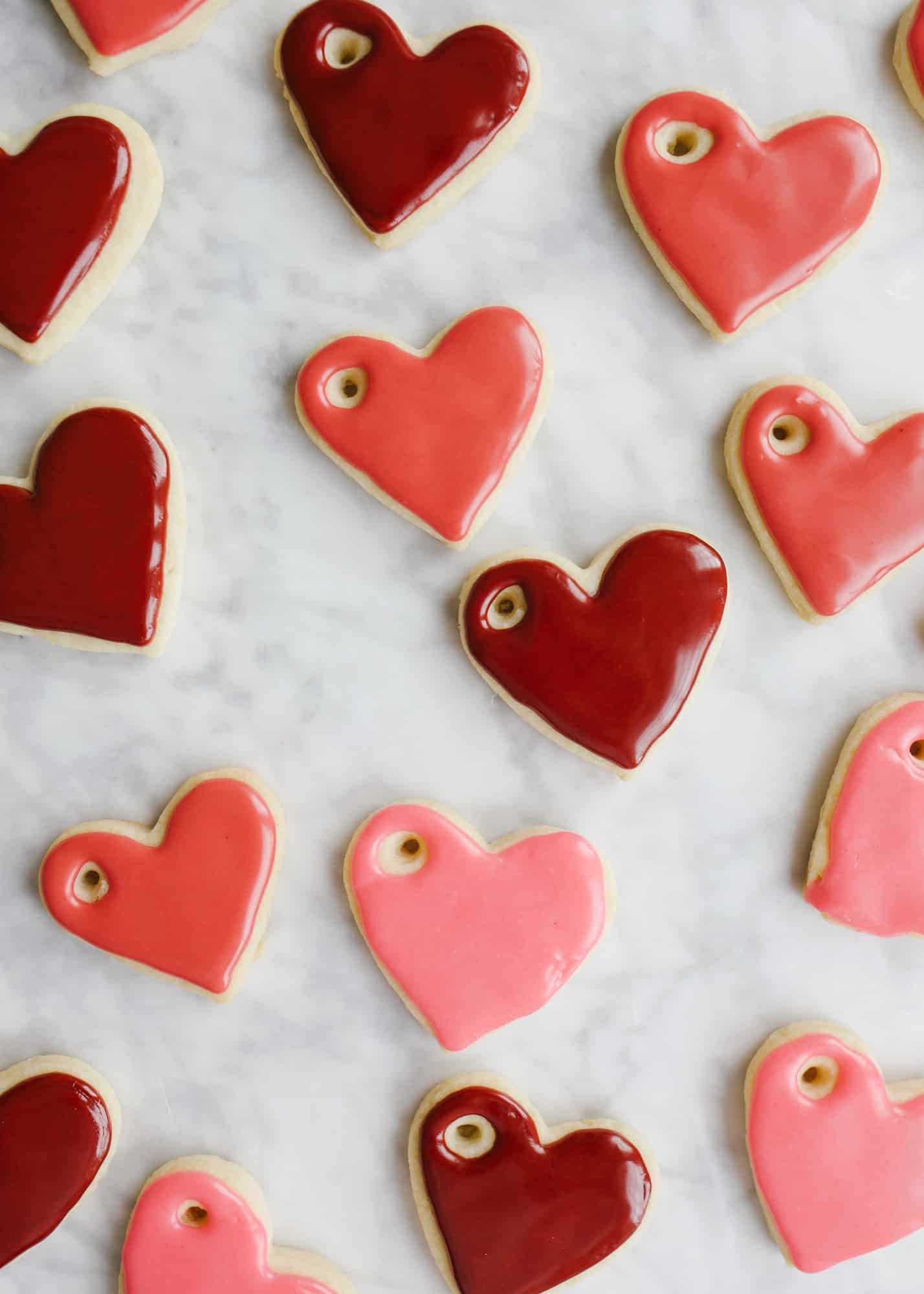 Sugar Cookie Gift Tags by Wood and Spoon blog. Use this tutorial to create, mini frosted iced heart sugar cookies to use as garland, napkin ring holders, gift tags, name tags, necklaces, and more. This simple tutorial gives you the DIY recipe for hard set cookies with homemade icing and ideas for how to use them for Valentine's Day parties, kid crafts, and more. Read about the recipe and how to on thewoodandspoon.com by Kate Wood