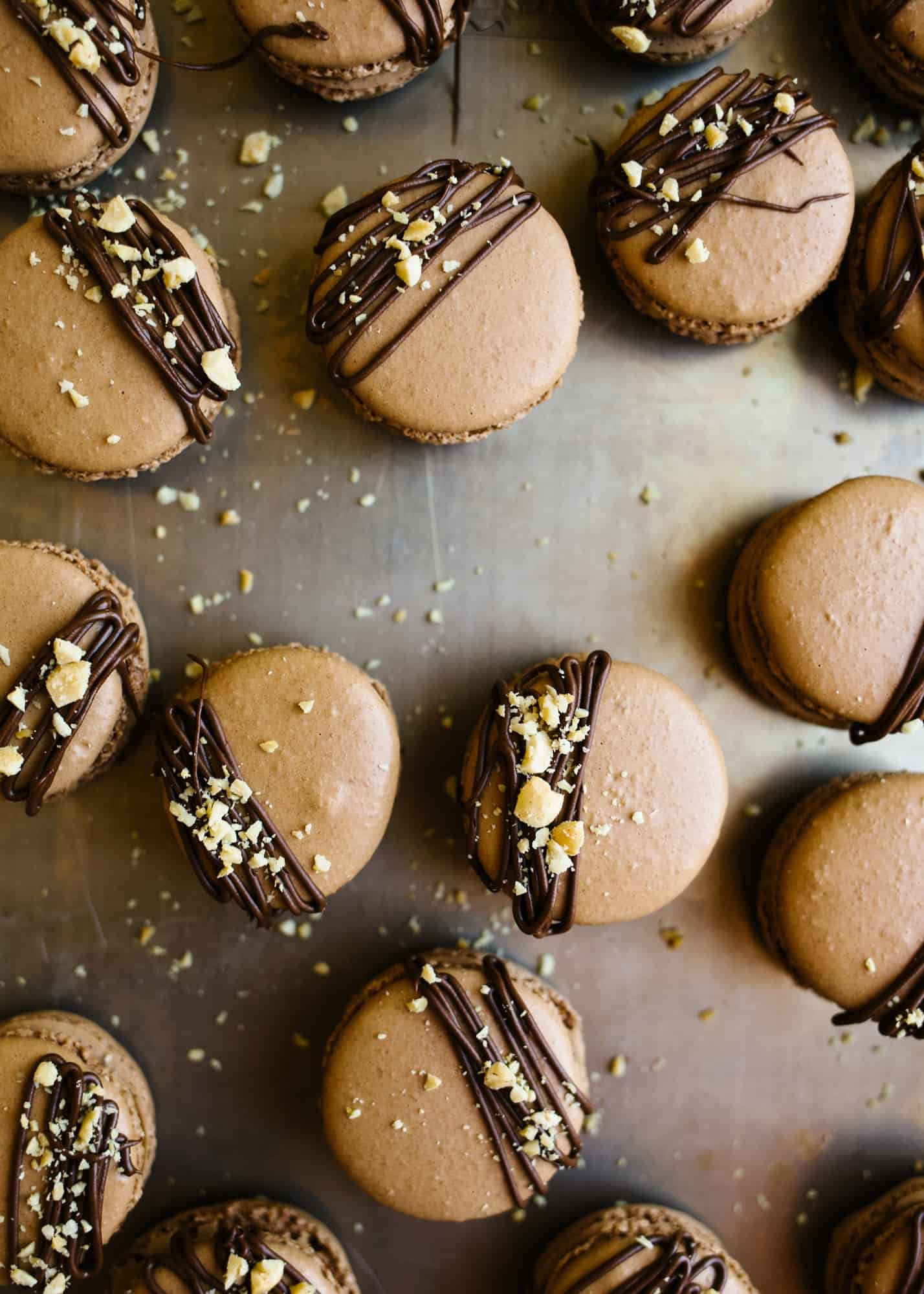 Chocolate Peanut Butter Caramel Macarons by Wood and Spoon blog. Chocolate french macarons are made with cocoa powder and filled with a simple peanut butter caramel that is made on the stovetop. The end product is a yummy and fun fancy treat perfect for the fall weather and chocolate lovers. Learn more on how to make macarons on thewoodandspoon.com