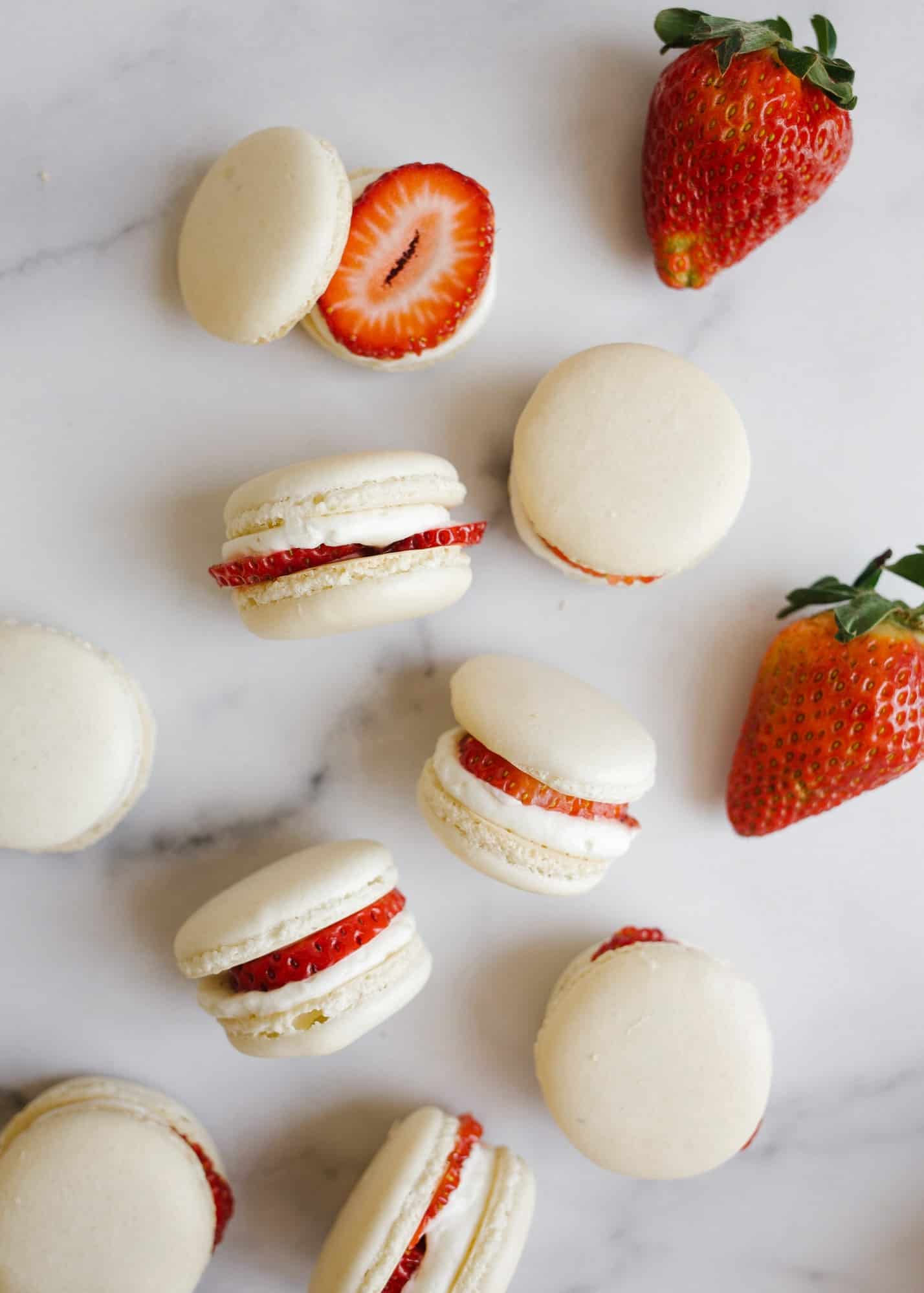 Strawberry Shortcake Macarons and Mother's Day gift guide by wood and spoon. These are simple homemade macarons filled with whipped cream, strawberry jam, and fresh fruit. These taste like a shortcake in cookie form. Gifts for mom's on your list including cookbook, jewelry, beauty and home supplies, and more. Read all about these fancy spring desserts and learn how to make them on thewoodandspoon.com