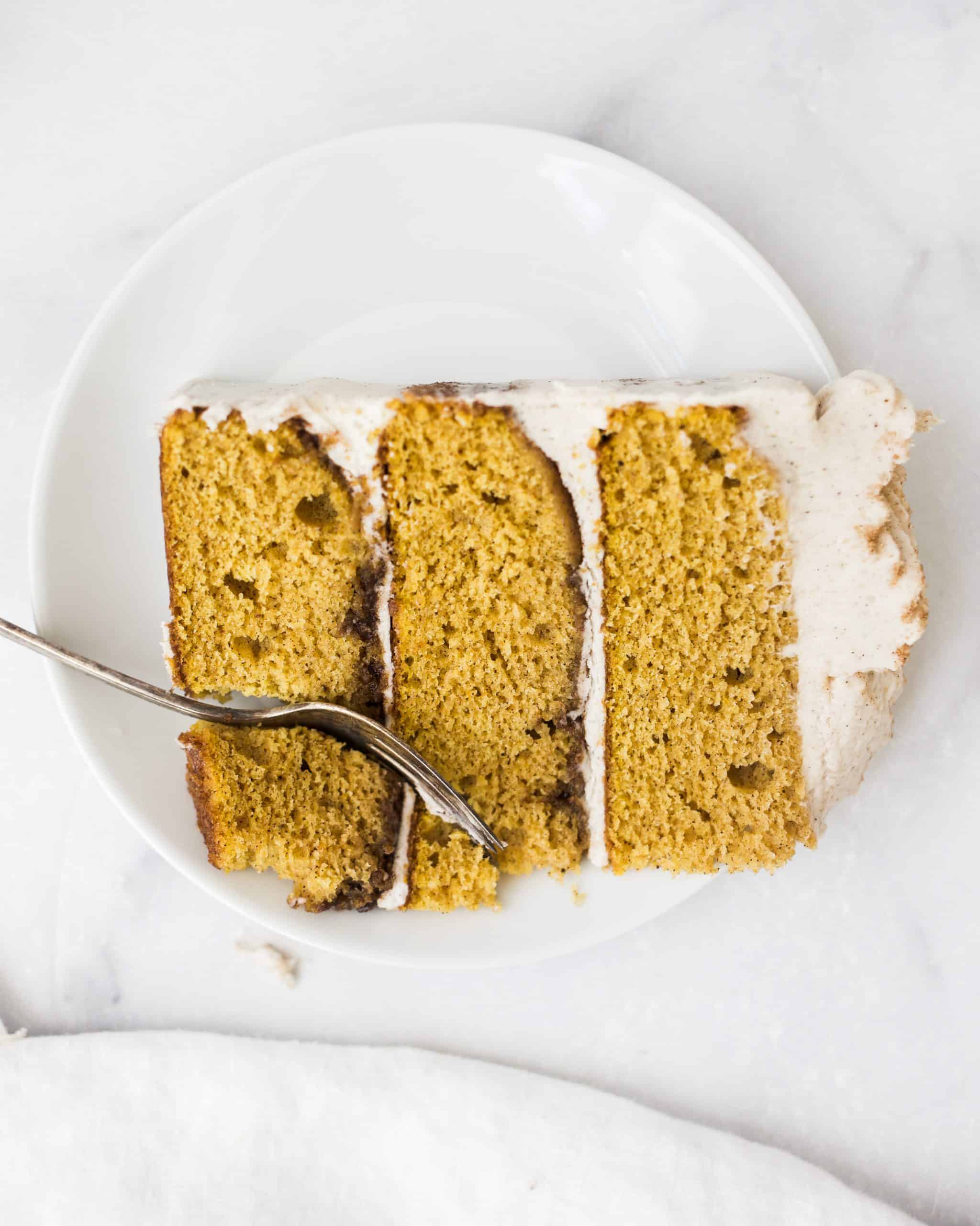 Pumpkin Layer Cake by Wood and Spoon blog. This is a fluffy and moist pumpkin cake layers with cinnamon sugar buttercream. This dessert is a spiced cake perfect for fall or winter holidays. To learn how to make a festive cake for thanksgiving or fall, check out the recipe and how-to on thewoodandspoon.com