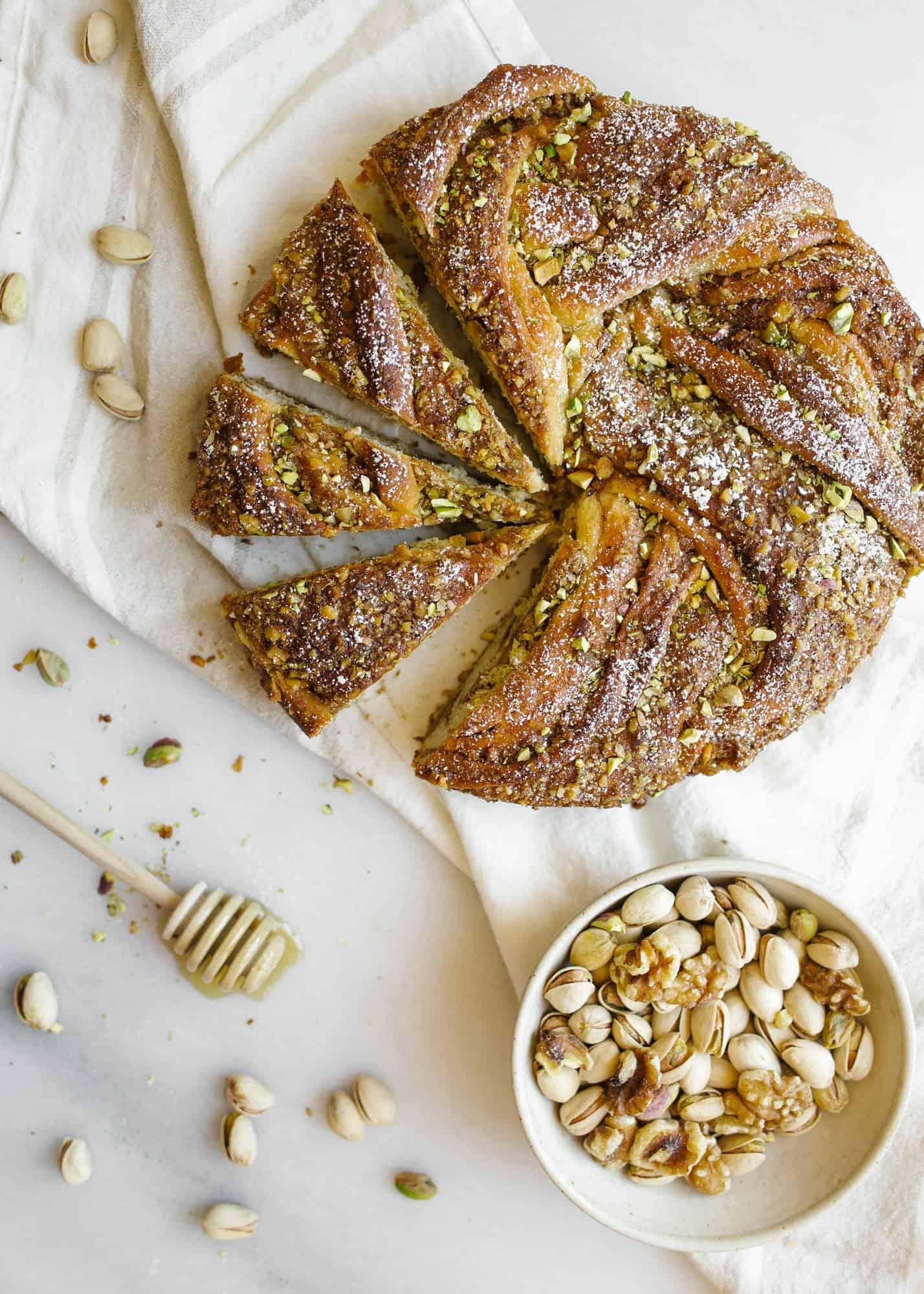 Braided Baklava Brioche by Wood and Spoon. This is a wreath loaf inspired by the meditteranean dessert filled with cinnamon, honey, walnuts, and pistachios. The yeast dough is sweetened with brown sugar and honey syrup and the crunchy nut filling adds flavor and texture. Heat up warm slices as a dessert or for breakfast. Learn more and how to braid the bread on thewoodandspoon.com