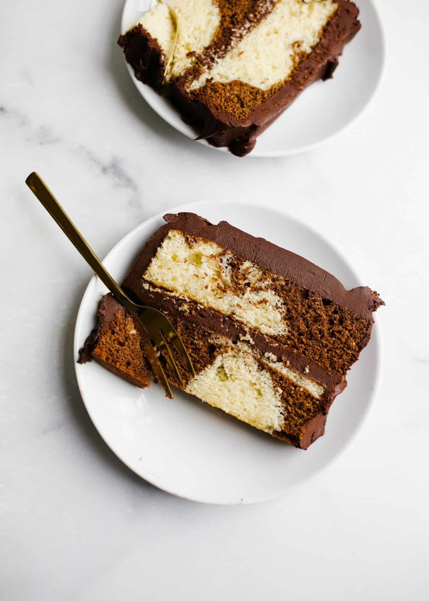 Marble Layer Cake by Wood and Spoon blog. This is a small batch mini chocolate and vanilla swirl cake with a rich fudge frosting. Perfect for smaller serving size or family size. This cake can be made as a sheet cake or a small stacked cake. Learn how to swirl cake batters and make this delicious half and half cake on thewoodandspoon.com