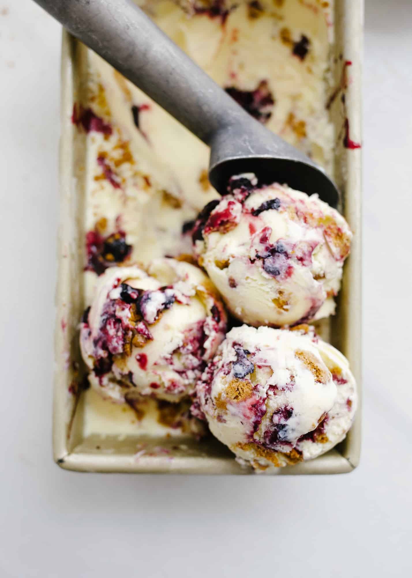 Blueberry Mascarpone Ice Cream this is a frozen dessert adapted from Daniel Humm made with mascarpone cheese and vanilla bean. There is a biscoff cookie (speculoos cookie butter) crumb and a blueberry sauce swirled throughout to give this ice cream a berry crisp flavor. Find the recipe for this ice cream machine recipe and learn how to make it homemade on thewoodandspoon.com