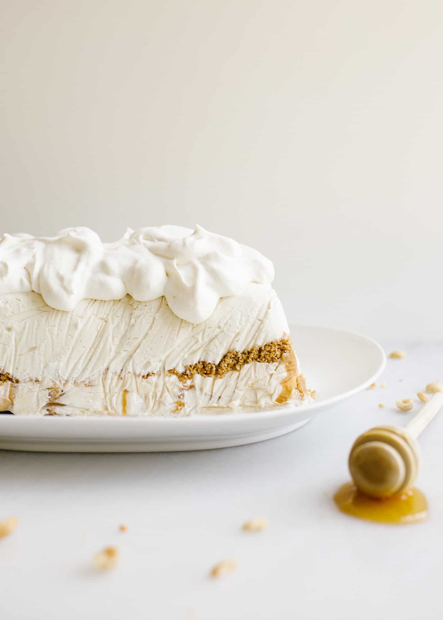 Peanut Butter Honey Graham Ice Cream Cake by Wood and Spoon blog. This is a no-churn ice cream loaf cake with a graham crumble, peanut butter ice cream, honey ice cream, and a swirl of peanut butter throughout The whole thing is topped with whipped cream and cake be made ahead to be served as a simple summer dessert. Learn how to make this homemade ice cream cake here on thewoodandspoon.com