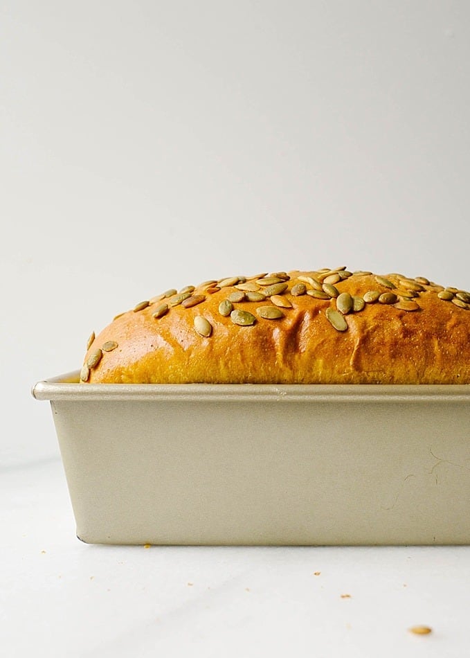 Pumpkin Yeast Bread Recipe by The Wood and Spoon Blog by Kate Wood. This is a fluffy, simple, sandwich yeast bread seasoned with cinnamon, pumpkin puree, and seeds. Perfect for the holidays, thanksgiving and christmas leftovers, this bread is excellent for toast and snacking and makes and excellent idea for hostess host gift. Find the recipe and more info on how to make bread without a bread machine maker on thewoodandspoon.com