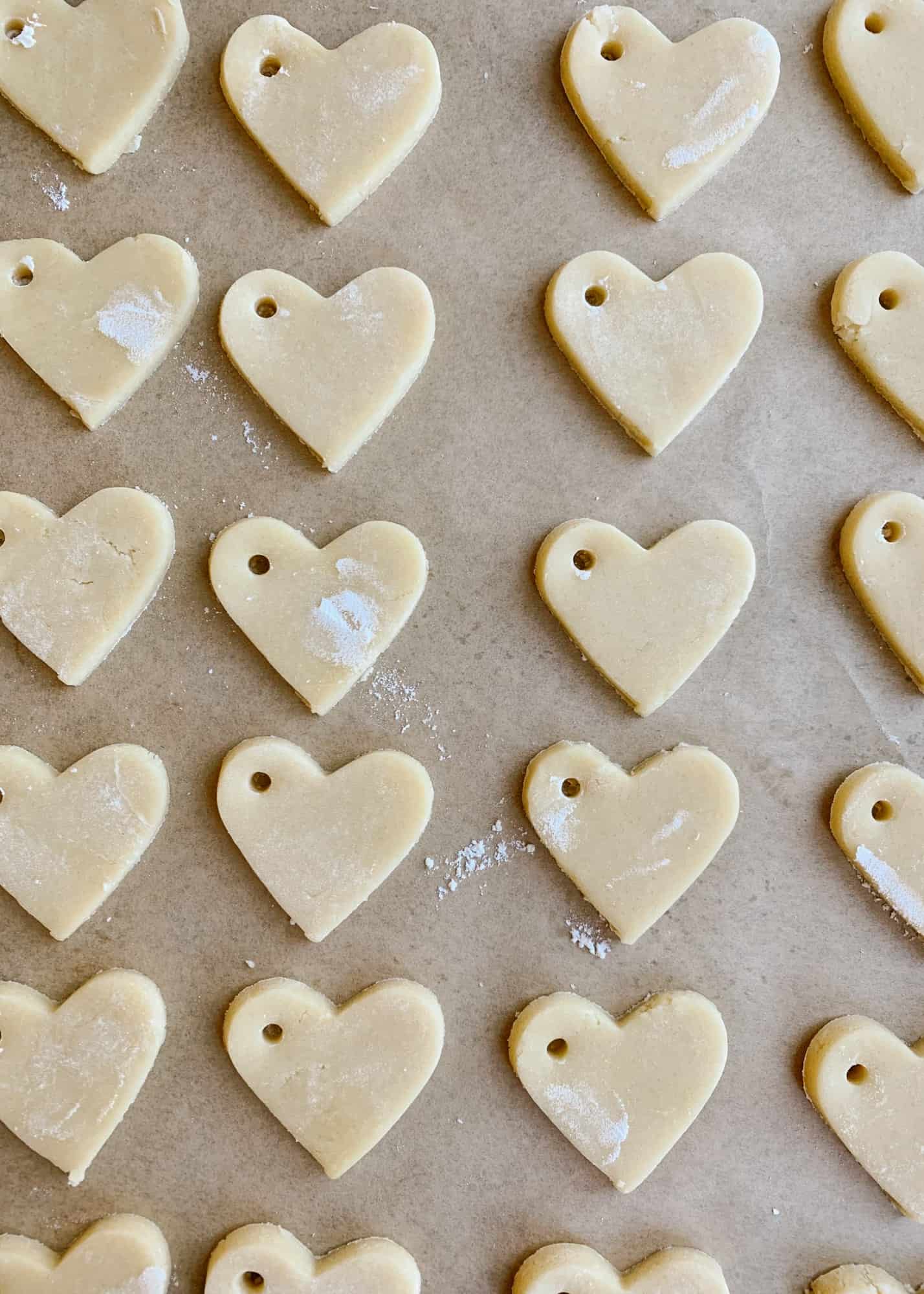 Sugar Cookie Gift Tags by Wood and Spoon blog. Use this tutorial to create, mini frosted iced heart sugar cookies to use as garland, napkin ring holders, gift tags, name tags, necklaces, and more. This simple tutorial gives you the DIY recipe for hard set cookies with homemade icing and ideas for how to use them for Valentine's Day parties, kid crafts, and more. Read about the recipe and how to on thewoodandspoon.com by Kate Wood