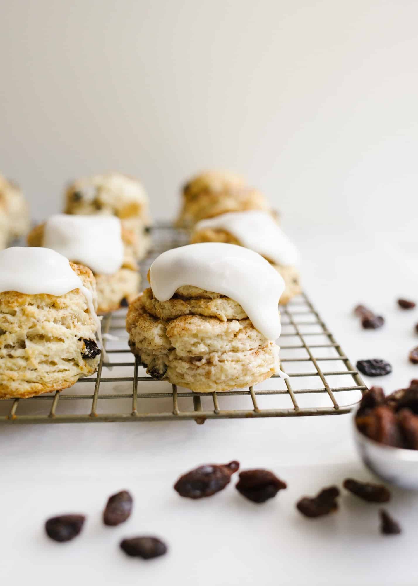 Cinnamon Raisin Biscuits by Wood and Spoon blog. These are layered Southern style buttermilk biscuits with a cinnamon sugar filling and raisins. A copycat recipe of Hardee's biscuits! The butter glaze is simple and adds extra sweet to these breakfast pastries. These fluffy biscuits make a great breakfast or brunch option and reheat well so you can make in advance as well. Find the recipe and how to for making tall flaky biscuits on thewoodandspoon.com