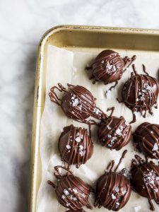 Cookie Dough Truffles by Wood and Spoon. These are eggless cookie dough balls that are dipped in melted dark chocolate and sprinkled with sea salt. The finished product are mini homemade chocolate truffles that are perfect for cookie dough lovers. Learn how simple the recipe is on thewoodandspoon.com